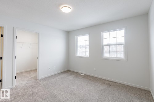 Unfurnished bedroom with a walk in closet and light carpet - 75 Dansereau Way, Beaumont, AB - Indoor Photo Showing Other Room