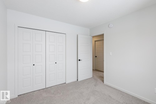 Unfurnished bedroom featuring light colored carpet and a closet - 75 Dansereau Way, Beaumont, AB - Indoor