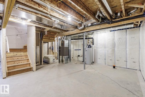 Unfinished basement featuring heating unit and water heater - 75 Dansereau Way, Beaumont, AB - Indoor Photo Showing Basement