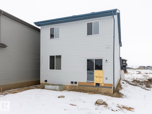 View of snow covered back of property - 75 Dansereau Way, Beaumont, AB - Outdoor With Exterior