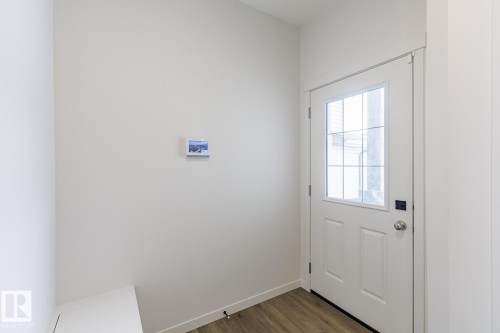 Doorway featuring wood finished floors and baseboards - 75 Dansereau Way, Beaumont, AB - Indoor Photo Showing Other Room