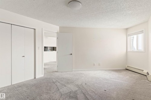 Unfurnished bedroom with a textured ceiling and carpet - 312 11620 9A Avenue, Edmonton, AB - Indoor Photo Showing Other Room