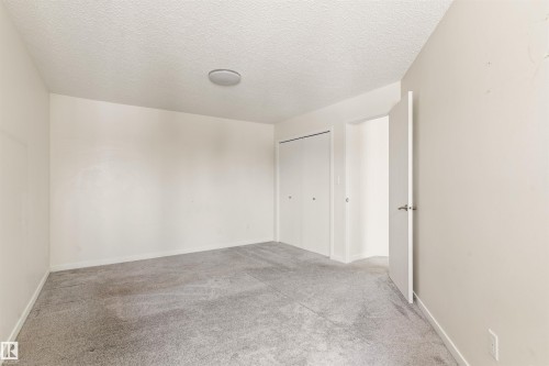 Unfurnished room with a textured ceiling and light colored carpet - 312 11620 9A Avenue, Edmonton, AB - Indoor Photo Showing Other Room