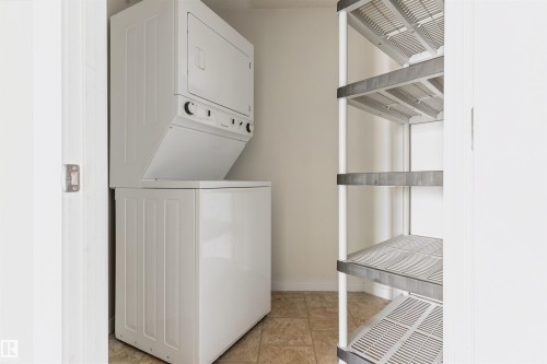 Laundry room with stacked washer / drying machine and baseboards - 312 11620 9A Avenue, Edmonton, AB - Indoor Photo Showing Laundry Room