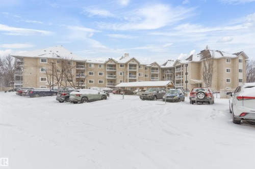 Snow covered parking area with uncovered parking - 312 11620 9A Avenue, Edmonton, AB - Outdoor With Balcony With Facade