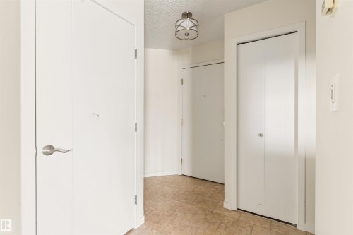 Hallway with a textured ceiling and stone finish flooring - 312 11620 9A Avenue, Edmonton, AB - Indoor Photo Showing Other Room