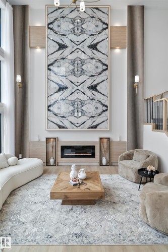 Living area with a glass covered fireplace and wood finished floors - 7026 Kiviaq Crescent, Edmonton, AB - Indoor Photo Showing Living Room With Fireplace