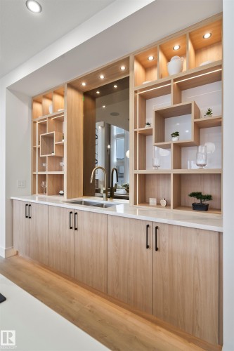 Bar area with light wood finish cabinets, light wood-style floors, modern cabinets, open shelves, and light stone countertops - 7026 Kiviaq Crescent, Edmonton, AB - Indoor Photo Showing Kitchen