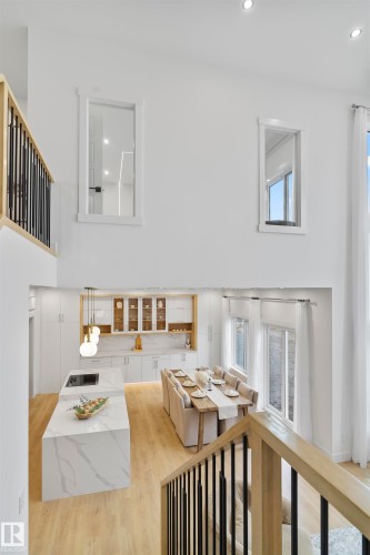 Living area featuring plenty of natural light, light wood finished floors, recessed lighting, and a high ceiling - 7026 Kiviaq Crescent, Edmonton, AB - Indoor Photo Showing Other Room