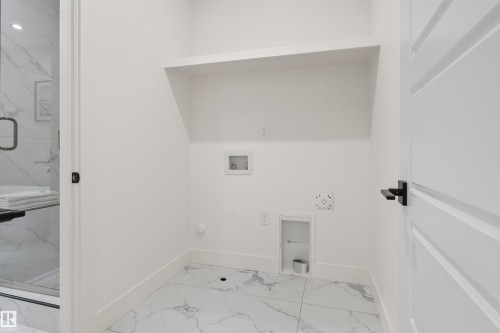 Laundry area with light marble finish floors, hookup for a washing machine, and gas dryer hookup - 7026 Kiviaq Crescent, Edmonton, AB - Indoor