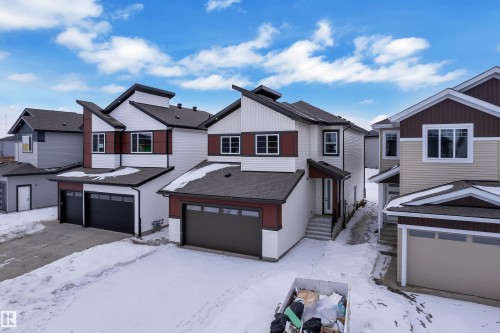 View of front of house with a residential view, a shingled roof, and an attached garage - 741 Astoria Way, Devon, AB - Outdoor With Facade