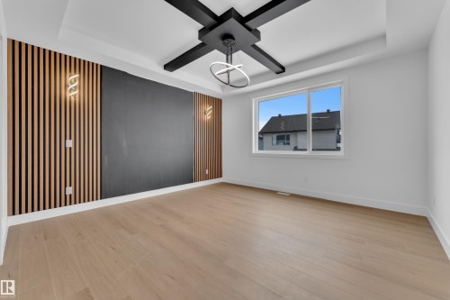 Empty room with a raised ceiling, light wood-type flooring, and a ceiling fan - 741 Astoria Way, Devon, AB - Indoor Photo Showing Other Room