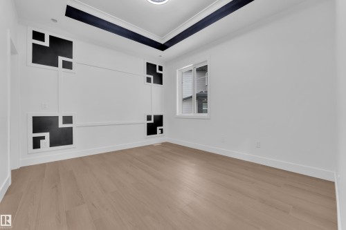 Empty room with light wood-style flooring and a raised ceiling - 215 Basin Court, Leduc, AB - Indoor Photo Showing Other Room