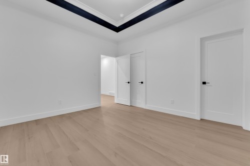 Unfurnished bedroom with light wood-style floors and ornamental molding - 215 Basin Court, Leduc, AB - Indoor Photo Showing Other Room