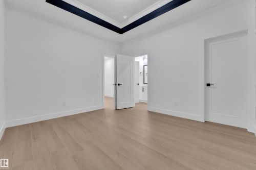 Unfurnished bedroom featuring ensuite bathroom, light wood-style floors, and crown molding - 215 Basin Court, Leduc, AB - Indoor Photo Showing Other Room
