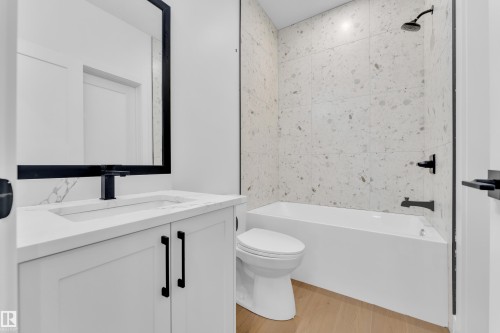 Bathroom with vanity, light wood-type flooring, and washtub / shower combination - 215 Basin Court, Leduc, AB - Indoor Photo Showing Bathroom