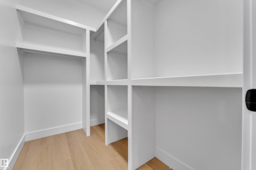 Walk in closet featuring light wood-style flooring - 215 Basin Court, Leduc, AB - Indoor With Storage
