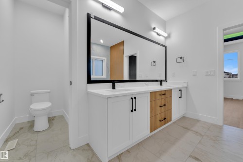 Full bath featuring light marble finish floors and double vanity - 215 Basin Court, Leduc, AB - Indoor Photo Showing Bathroom