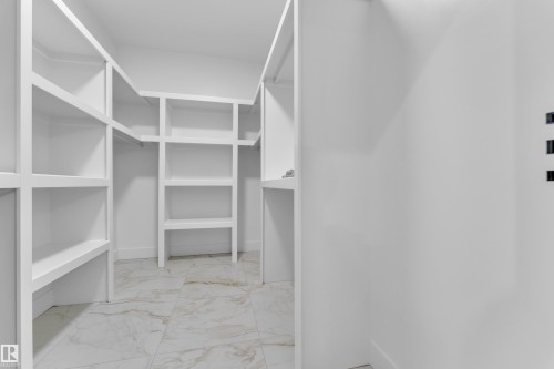 Walk in closet with light marble finish flooring - 215 Basin Court, Leduc, AB - Indoor With Storage