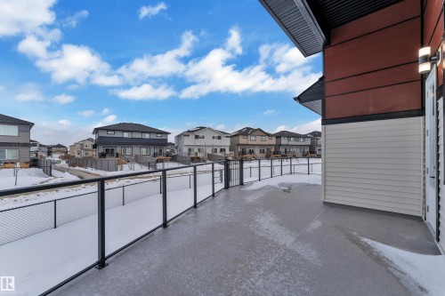 Snow covered back of property featuring a residential view - 215 Basin Court, Leduc, AB - Outdoor With Exterior