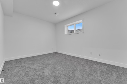 Spare room featuring baseboards and carpet - 215 Basin Court, Leduc, AB - Indoor Photo Showing Other Room