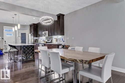 Dining space featuring dark wood-type flooring and a chandelier - 10806 72 Avenue, Edmonton, AB - Indoor Photo Showing Dining Room