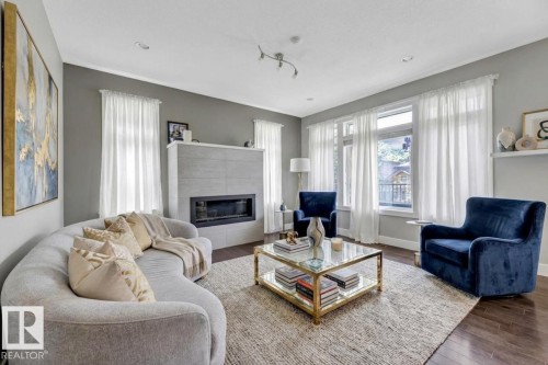 Living room with wood finished floors and a fireplace - 10806 72 Avenue, Edmonton, AB - Indoor Photo Showing Living Room With Fireplace