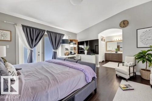 Bedroom featuring vaulted ceiling, dark wood-style flooring, arched walkways, and ensuite bath - 10806 72 Avenue, Edmonton, AB - Indoor Photo Showing Bedroom