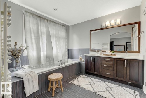 Full bath featuring double vanity, a garden tub, and wainscoting - 10806 72 Avenue, Edmonton, AB - Indoor Photo Showing Bathroom