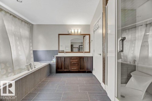 Full bath featuring double vanity, a garden tub, a wainscoted wall, and a stall shower - 10806 72 Avenue, Edmonton, AB - Indoor Photo Showing Bathroom
