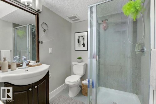 Bathroom with vanity, a textured ceiling, and a shower stall - 10806 72 Avenue, Edmonton, AB - Indoor Photo Showing Bathroom