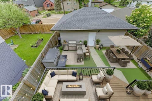 Fenced backyard featuring an outdoor fire pit, a patio, an outdoor living / dining area, a residential view, and grilling area - 10806 72 Avenue, Edmonton, AB - Outdoor