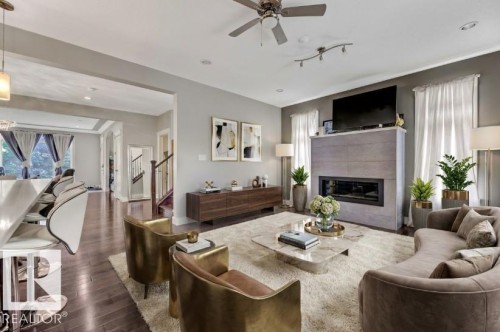 Living area with ceiling fan, dark wood-type flooring, a tile fireplace, and recessed lighting - 10806 72 Avenue, Edmonton, AB - Indoor Photo Showing Living Room With Fireplace