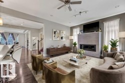 Living area with ceiling fan, dark wood-type flooring, a tile fireplace, and recessed lighting - 