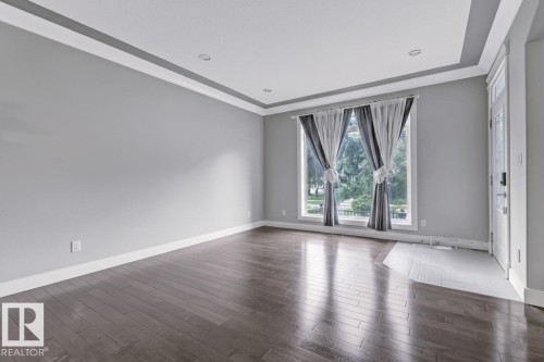 Empty room featuring dark wood-style floors and a raised ceiling - 10806 72 Avenue, Edmonton, AB - Indoor Photo Showing Other Room