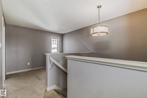 Hall featuring an upstairs landing and light carpet - 1669 Hammond Crescent, Edmonton, AB - Indoor Photo Showing Laundry Room
