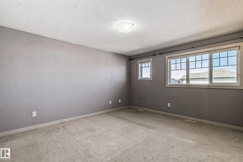 Unfurnished room with light colored carpet and a textured ceiling - 1669 Hammond Crescent, Edmonton, AB - Indoor Photo Showing Other Room