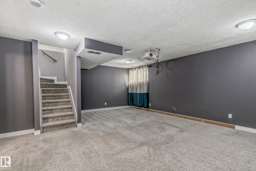 Below grade area with a textured ceiling and light colored carpet - 1669 Hammond Crescent, Edmonton, AB - Indoor Photo Showing Other Room