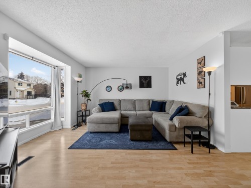 Living room featuring light wood-style floors and a textured ceiling - 4603 32 Avenue, Edmonton, AB - Indoor Photo Showing Living Room