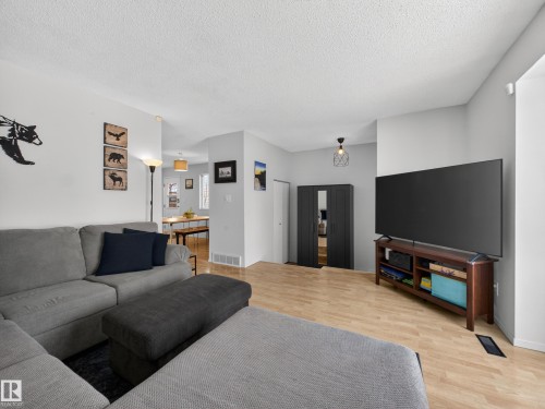 Living room with light wood-style floors and a textured ceiling - 4603 32 Avenue, Edmonton, AB - Indoor Photo Showing Living Room