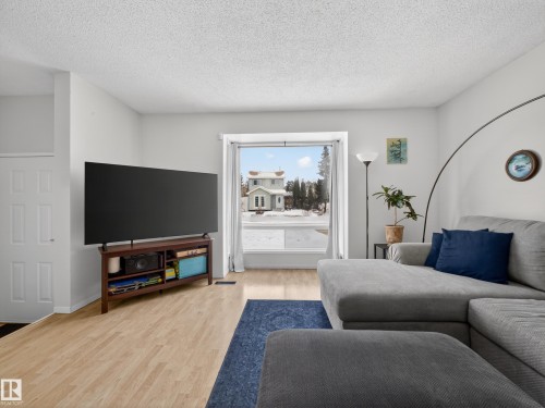 Living room featuring light wood-style floors and a textured ceiling - 4603 32 Avenue, Edmonton, AB - Indoor Photo Showing Living Room