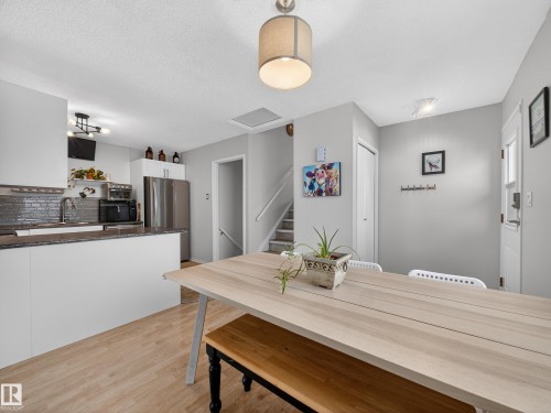 Dining room with light wood-type flooring and a textured ceiling - 4603 32 Avenue, Edmonton, AB - Indoor