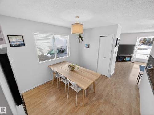 Dining room with light wood-type flooring and a textured ceiling - 4603 32 Avenue, Edmonton, AB - Indoor Photo Showing Dining Room
