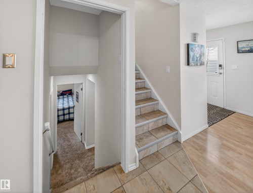 Stairway with tile patterned floors, carpet floors, and a textured ceiling - 4603 32 Avenue, Edmonton, AB - Indoor Photo Showing Other Room