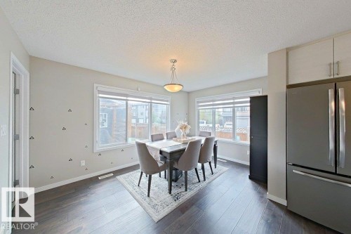 Dining area featuring a textured ceiling, dark wood finished floors, and healthy amount of natural light - 4303 Prowse Link, Edmonton, AB - Indoor Photo Showing Dining Room