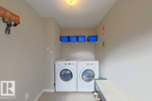 Laundry room featuring separate washer and dryer and a textured ceiling - 4303 Prowse Link, Edmonton, AB - Indoor Photo Showing Laundry Room