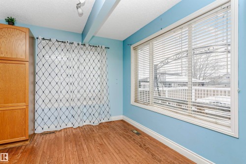 Unfurnished room featuring beamed ceiling, light wood-style floors, and a textured ceiling - 607 Windross Crescent, Edmonton, AB - Indoor Photo Showing Other Room