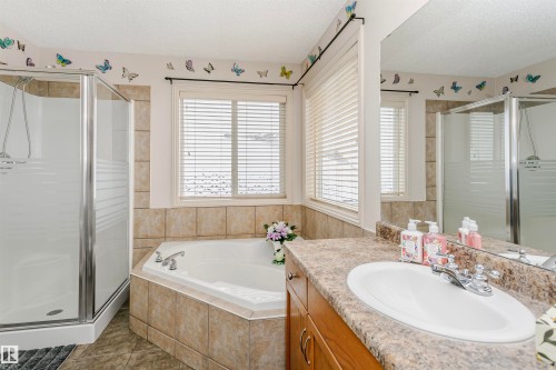 Bathroom with a stall shower, vanity, a textured ceiling, a bath, and tile patterned flooring - 607 Windross Crescent, Edmonton, AB - Indoor Photo Showing Bathroom