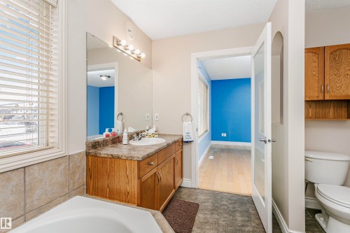 Bathroom with vanity, a garden tub, and dark tile patterned flooring - 607 Windross Crescent, Edmonton, AB - Indoor Photo Showing Bathroom