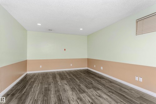 Spare room with dark wood finished floors, a textured ceiling, and recessed lighting - 607 Windross Crescent, Edmonton, AB - Indoor Photo Showing Other Room